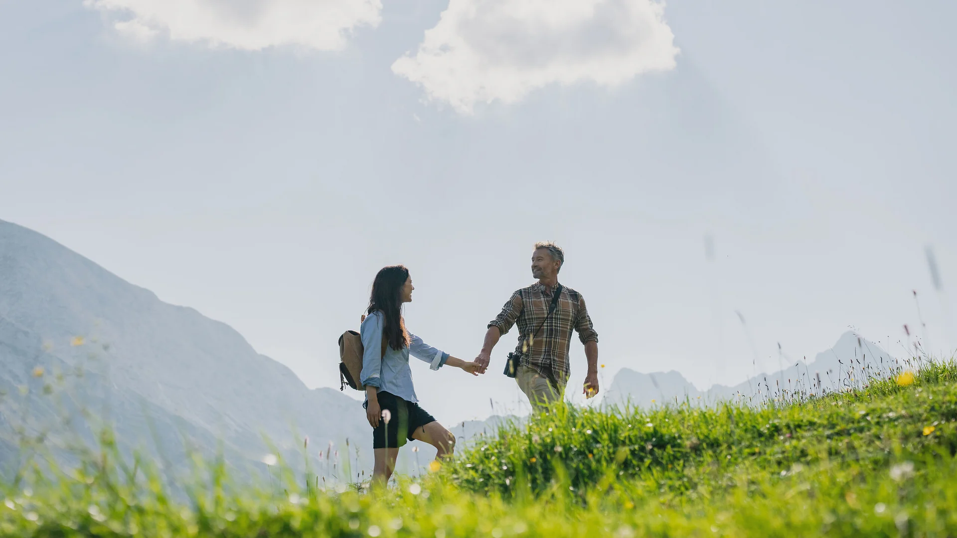 Urlaub in Bewegung: Ihr Aktivhotel in Tirol Paar beim Wandern in den Bergen an einem sonnigen Tag