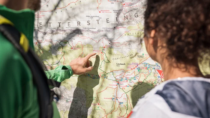 Person zeigt auf Wanderkarte der Alpenregion Wetterstein