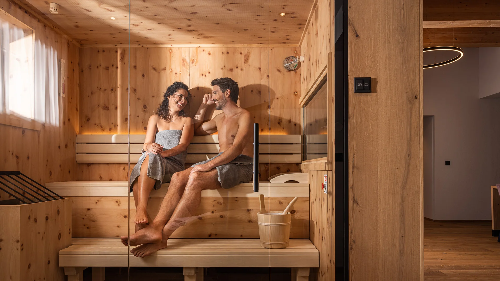 Kraftorte in Tirol: Biohotel Leutascherhof in Leutasch Paar entspannt sich zusammen in einer Sauna aus Holz