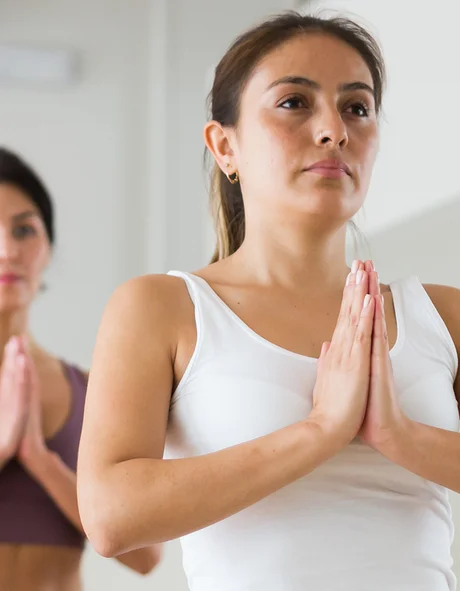 Menschen in Yogakurs im Baum-Pose auf Matten in Studio