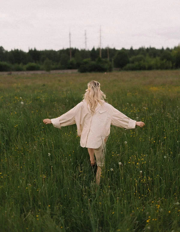 Your sport hotel in Austria: Leutascherhof Person walking with arms outstretched in a flower field