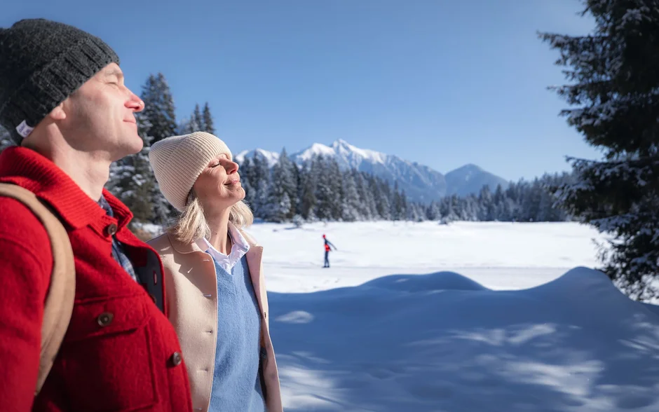 nachhaltig wirtschaften mit Sinn! Paar genießt die Wintersonne in verschneiter Berglandschaft