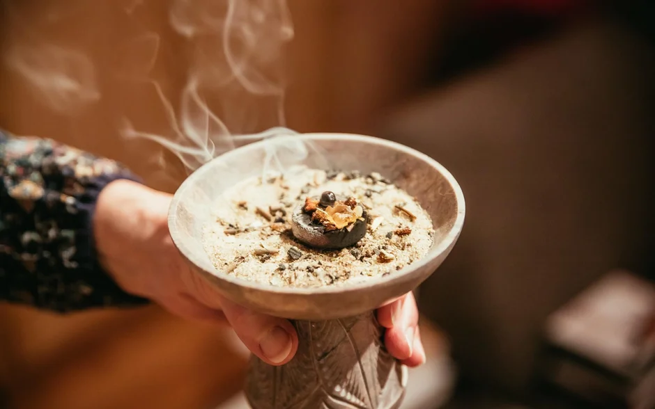 Räuchern - eine alte Tradition neu erleben Hand hält rauchende Schale mit Weihrauch und Sand